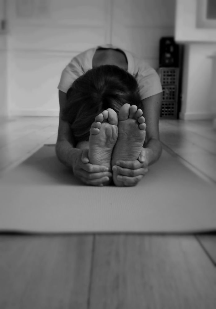 Posture de la pince : buste penché en avant sur les jambes tendues