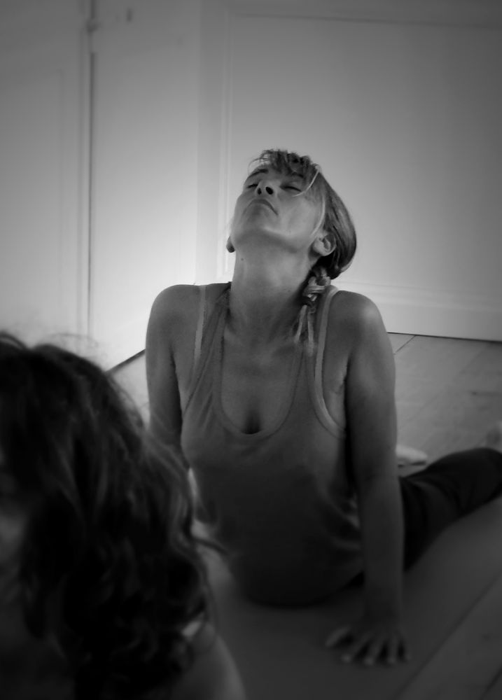 Pratiquante assise, tête en arrière et poitrine ouverte