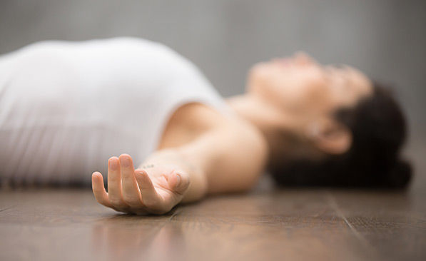 Relaxation profonde en yoga nidra, allongée au sol